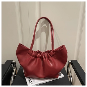 Detail of burgundy ruched cloud tote bag with soft texture and gold fashion logo