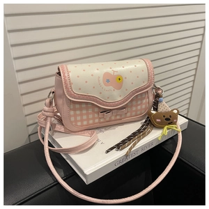 Detail of pink plaid crossbody bag with cream polka dot flap and bear plush charm