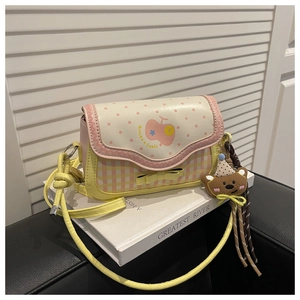 Detail of pink and yellow sweet crossbody bag with bow, dots and plush bear charm