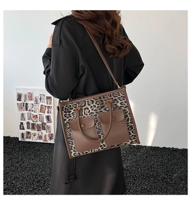 Detail of leopard print tote bag with brown leather pockets and shoulder strap style