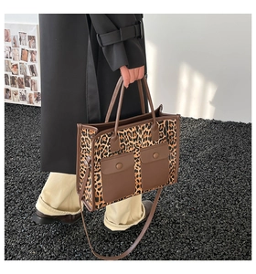 Detail of leopard print tote bag with brown leather pockets and dual shoulder straps