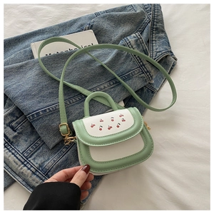 Detail of mint green handle and cherry print on white mini crossbody bag for girls