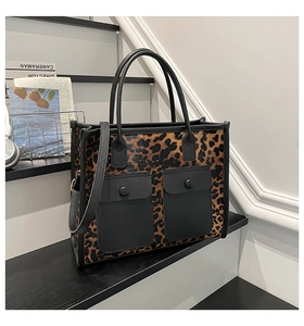 Close-up of leopard print tote bag with dual front flap pockets and black leather handles