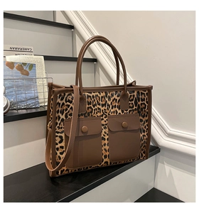Detail of leopard print tote bag featuring brown trim and stylish double front pockets