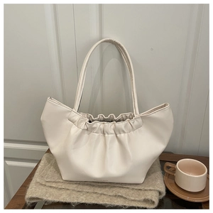 Macro view of creamy white pleated cloud bag with soft PU leather texture and hand strap