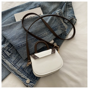 Detailed view of mini contrast crossbody bag with white PU body and dark brown trim