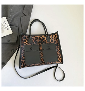 Detailed macro view of leopard print tote bag with dual front pockets and black leather trim