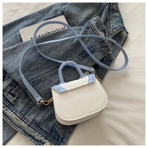 Close-up of kids mini saddle bag in blue and white PU leather with gold hardware detail