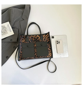 Top view of leopard print tote bag with black exterior pockets and urban commute accessories