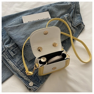 Detail of mini yellow and white crossbody bag showing interior capacity for cosmetics
