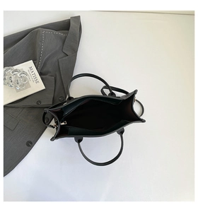 Top view of black tote bag interior showing dark brown lining and metal zipper pocket
