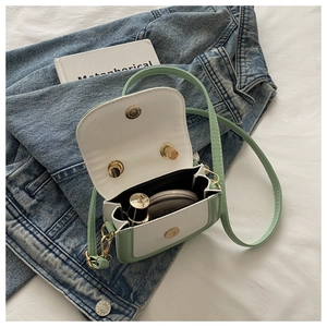 Detail view of mini mint green crossbody bag interior showing space for cosmetics
