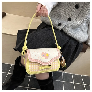 Detail of pink and yellow plaid handbag featuring a cute bow and apple pattern