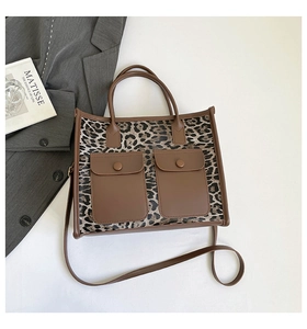 Detail view of leopard print tote bag with dual front pockets and brown leather straps