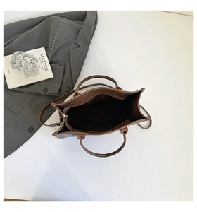 Top-down view of a spacious brown leather tote bag with deep brown lining and dual straps