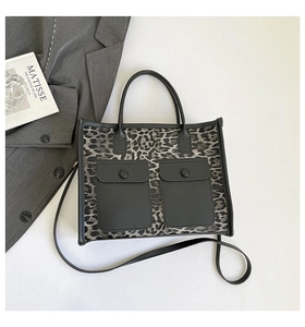 Detail of leopard print tote bag featuring dual front flap pockets and adjustable straps