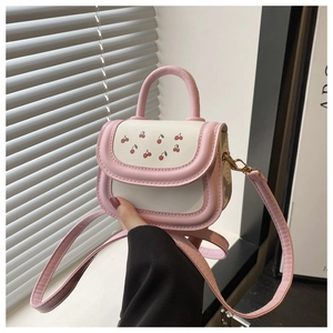 Detailed view of mini pink and white handbag with cherry print and dual carry handles