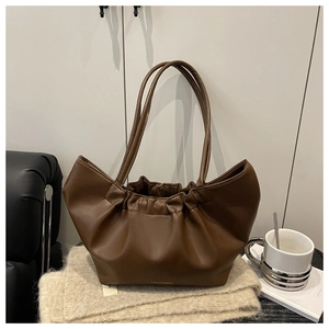 Close-up of dark brown ruched cloud handbag featuring gold fashion bags logo detail