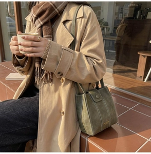 Olive green vintage textured leather bucket bag with contrasting white stitching detail
