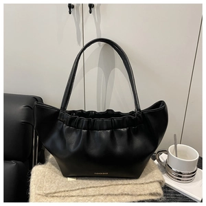 Detail of black pleated cloud tote bag with soft leather texture and fashion logo