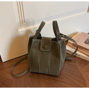 Detail view of vintage green bucket bag featuring white contrast stitching and soft suede texture