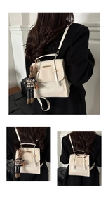 Detail of off-white convertible backpack with gold hardware and plaid bunny charm