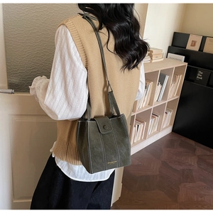 Detailed view of army green vintage bucket bag with contrast white stitching and logo