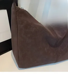 Vista dettagliata della borsa a spalla retrò marrone con trama usurata e zip in metallo