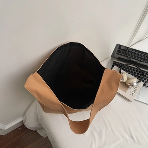 Grand sac cabas kaki minimaliste avec doublure noire présenté dans un décor lifestyle