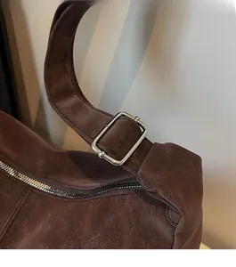 Dettaglio della borsa a tracolla marrone vintage con fibbia regolabile in metallo argento