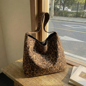 Grand sac cabas léopard élégant en toile épaisse posé sur un banc en bois