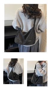 Dettaglio della grande borsa hobo nera in pelle scamosciata con scritta Niusu Studio
