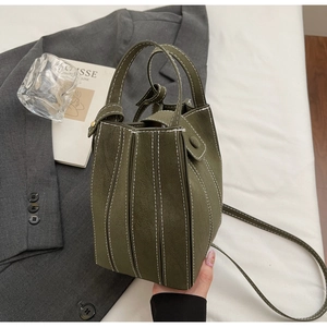 Detail view of olive green bucket bag with contrast stitching and matte texture