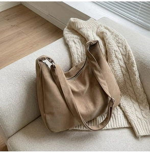 Dettaglio della borsa tote in pelle scamosciata kaki con tracolla larga e zip in metallo