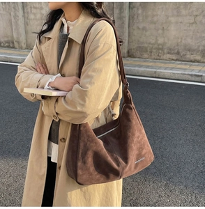 Dettaglio di una grande borsa tote in pelle scamosciata marrone con texture di qualità