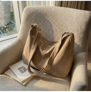 Dettaglio della borsa tote in pelle scamosciata marrone con logo in rilievo