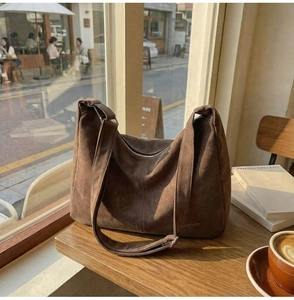 Dettaglio borsa hobo in pelle scamosciata marrone scuro con logo sulla finestra