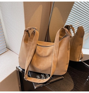 Dettaglio della borsa tote in pelle kaki con logo goffrato e tracolla regolabile
