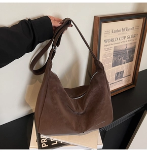 Dettaglio ravvicinato della borsa hobo marrone scuro con pelle morbida e cerniera