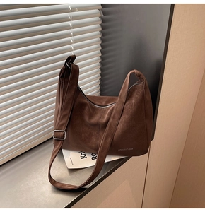 Dettaglio della borsa tote in finta pelle scamosciata marrone con tracolla regolabile