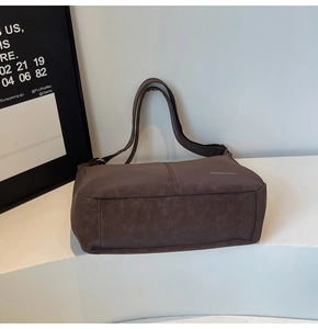 Dettaglio della borsa tote marrone grande con logo su espositore bianco pulito