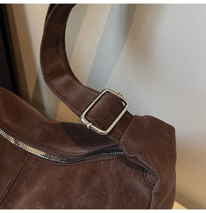 Macro di una borsa vintage in pelle marrone con fibbia in metallo argento e dettagli zip