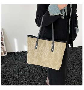 Quilted tote bag in khaki fabric with black leather handles and gold rivet details