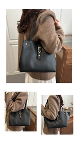 Detail of black large tote bag with gold oval buckle and premium faux leather finish