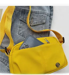 Detail view of yellow crossbody bag with functional front zipper pocket for phone