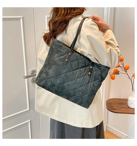 Close-up of diamond quilted camo tote bag with reinforced metallic rivets and strap