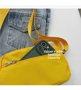 Detail view of yellow crossbody bag showing large zipper pocket for smartphones