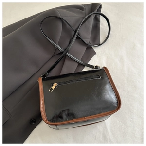 Detail view of the bag back featuring a zipper pocket and brown contrast trim