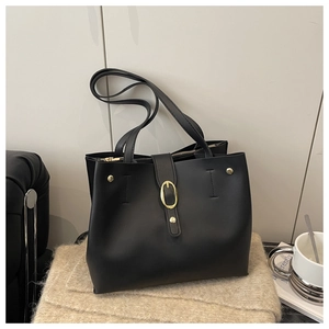 Detail view of black soft leather bucket bag with gold hardware and side zipper accents