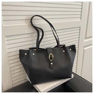 Detail view of the black soft leather tote bag featuring gold buckle and zipper closure